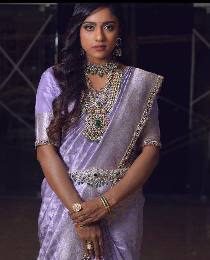 a woman in a purple sari and jewelry