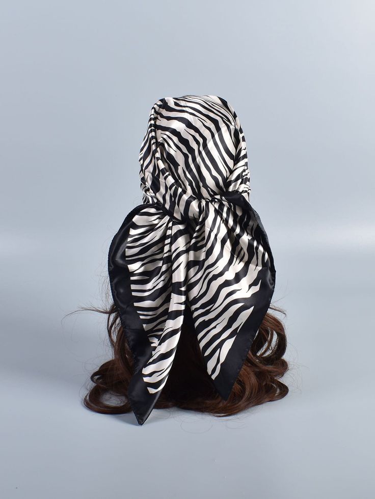 a woman with long hair wearing a black and white zebra print scarf on her head