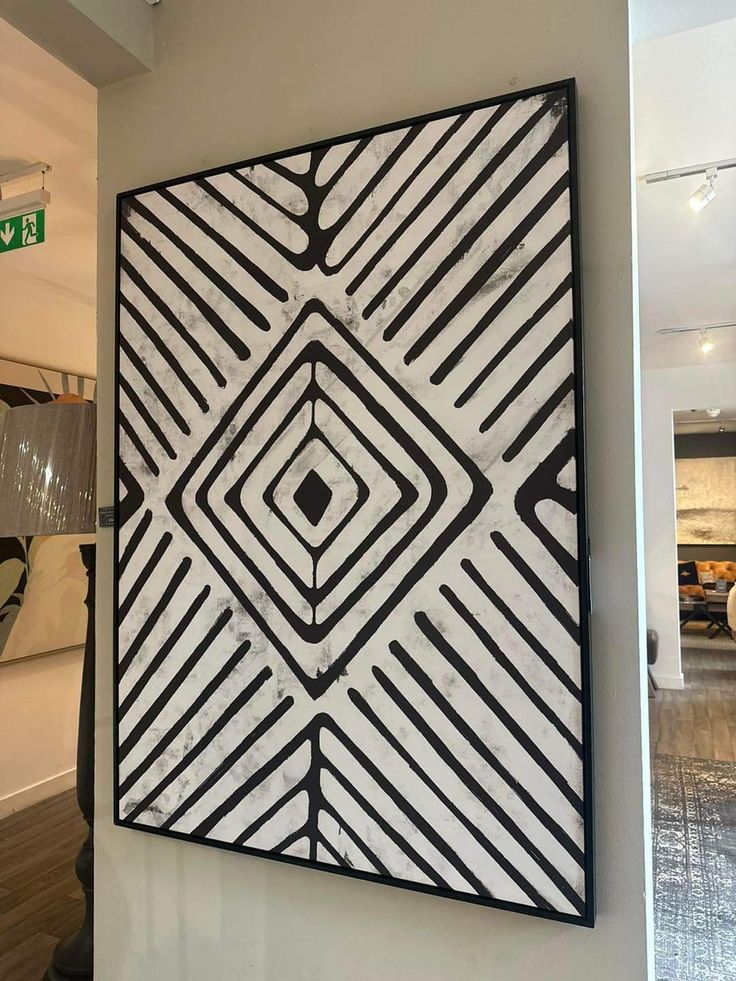 a black and white painting hanging on the wall