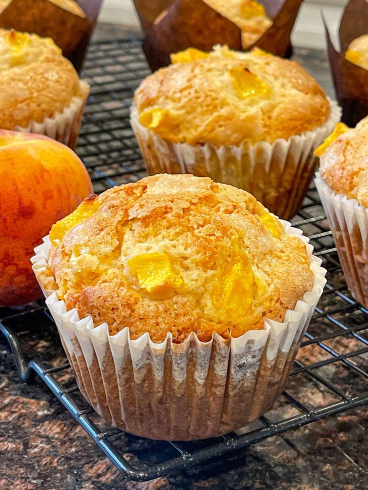 muffins cooling on a wire rack next to an apple