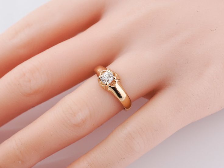 a woman's hand with a gold ring and diamond on the middle of her finger