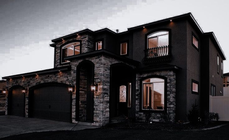 a large house with lots of windows and lights on it