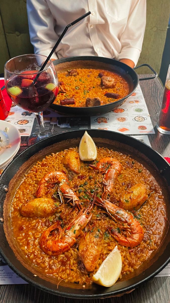 two pans filled with food sitting on top of a table next to each other