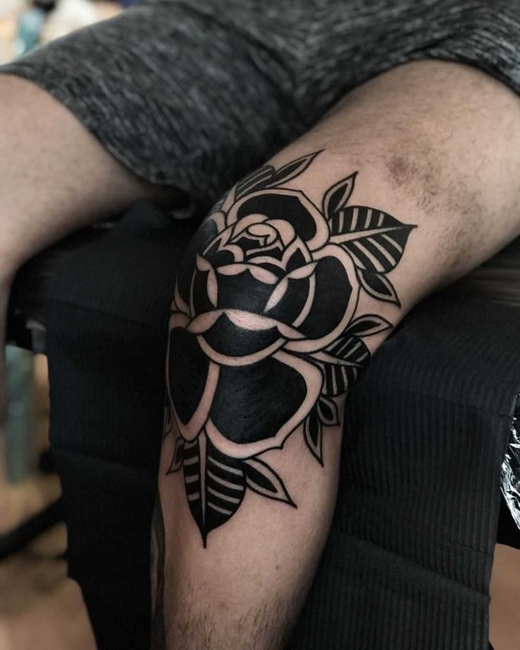 a man's arm with a rose tattoo on it, sitting in a chair