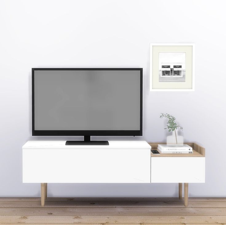 a flat screen tv sitting on top of a white entertainment center next to a plant