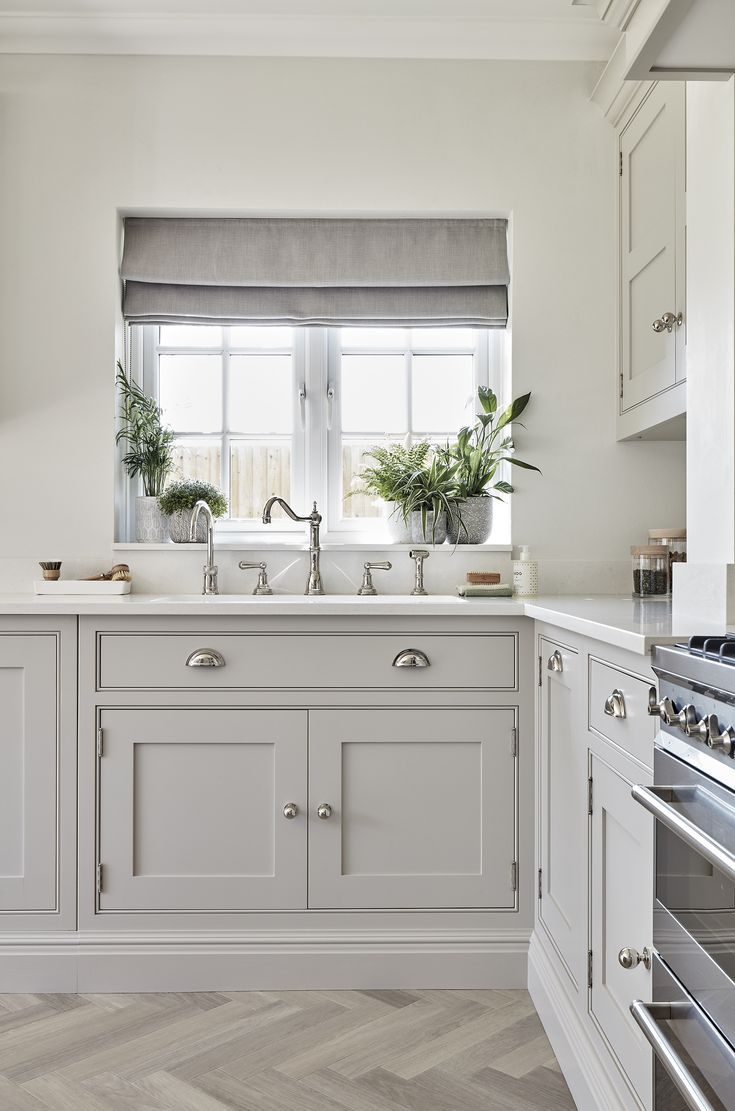 a kitchen with white cabinets and gray counter tops