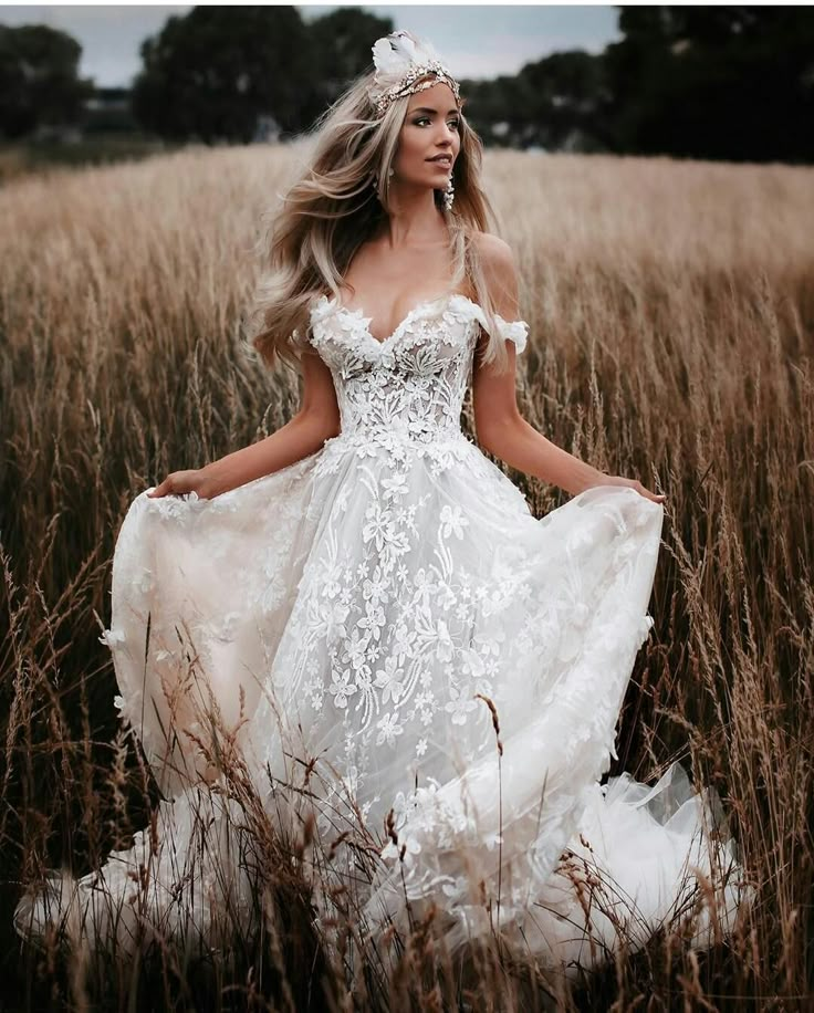 a woman in a white dress standing in tall grass