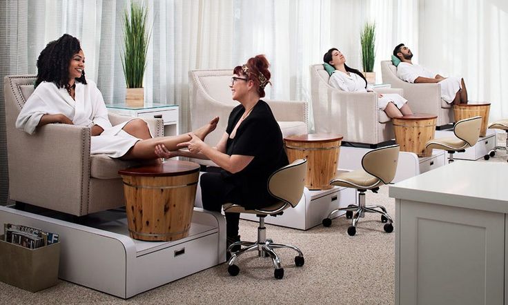 two women sitting in chairs talking to each other at the hairdresser's salon