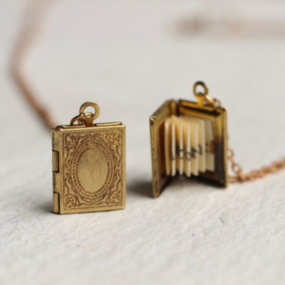 This exquisitely detailed little locket is a miniature book made from solid brass which has darkened over time to a rich gold colour.  Inside is a secret hidden message, specially folded and fitted inside the locket to look just like the pages of a real book! The locket has a perfectly working hinge and clasp and, if you wish, there is space inside for you to add two tiny photos.  The locket is a lovely and delicate size, measuring just 16mm x 10mm (about the size of a thumbnail).  The necklace Book Locket Necklace, Engraved Locket, Silk Purse, Personalized Book, Book Locket, Gold Engraving, Secret Messages, Proposal Gifts, Bookish Gifts