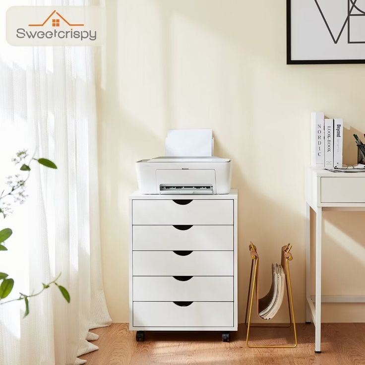 a white filing cabinet sitting next to a window in a room with wood flooring