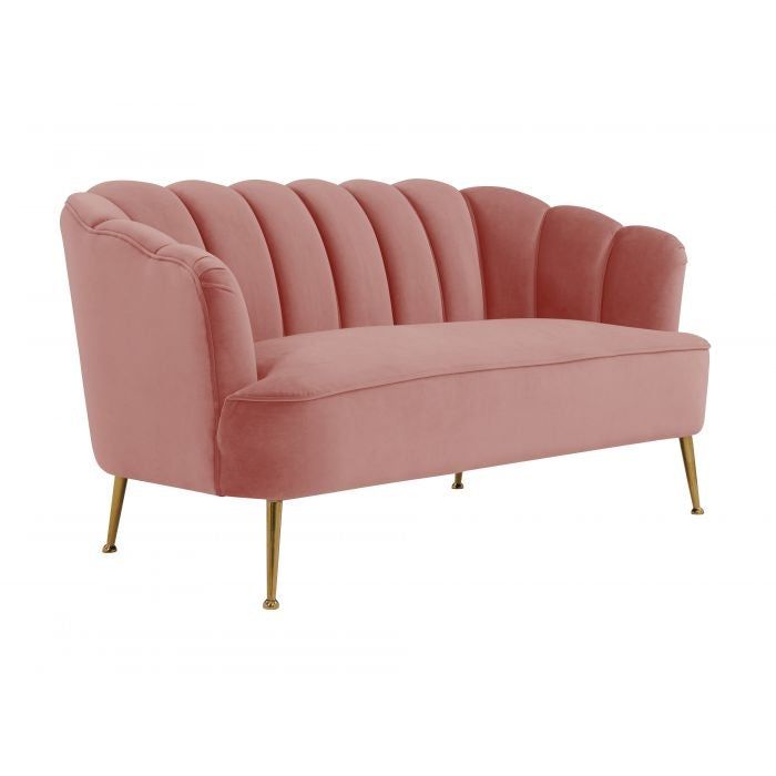 a pink velvet sofa with gold legs