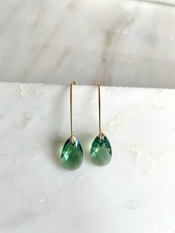 These stunning crystals hang simply alone, but with tons of sparkle. The pear-shaped drops measure 16mm and hang on plated kidney wires for a total length of about 1.75". The shade is erinite green which is bluish green. Perfect for everyday or special occasions. I have included a picture of the same design in a different shade for sizing purposes. Copyright © , all rights reserved LoveYourBling® is an authorized SWAROVSKI® Crystals Branding Partner. Long Crystal Earrings, Teardrop Earrings Gold, Bluish Green, Swarovski Crystal Earrings, Swarovski Earrings, Green Earrings, Green Crystals, Teardrop Earrings, Crystal Earrings