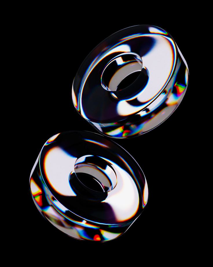 two shiny discs on a black background with some light reflecting off the top and bottom