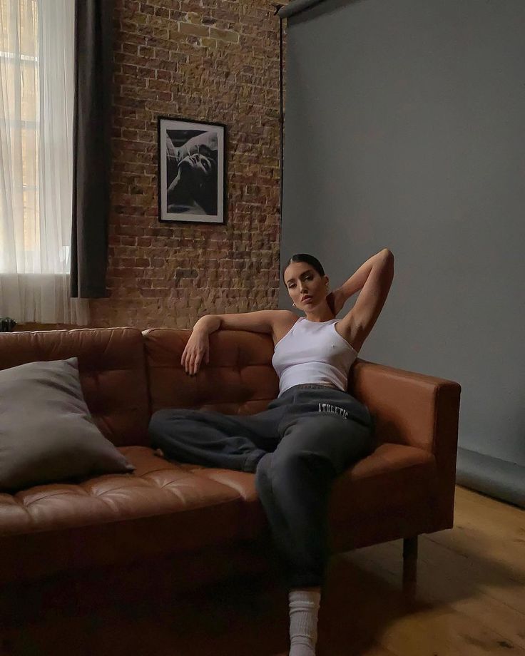 a woman sitting on top of a brown couch