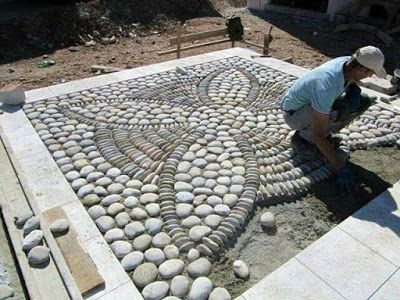 a man is working on some kind of stone work in the ground with his hands