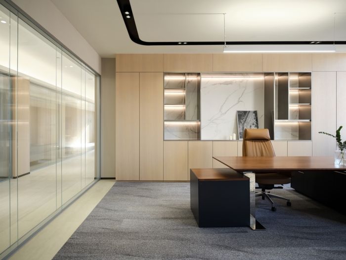 an office with glass walls and wooden desks