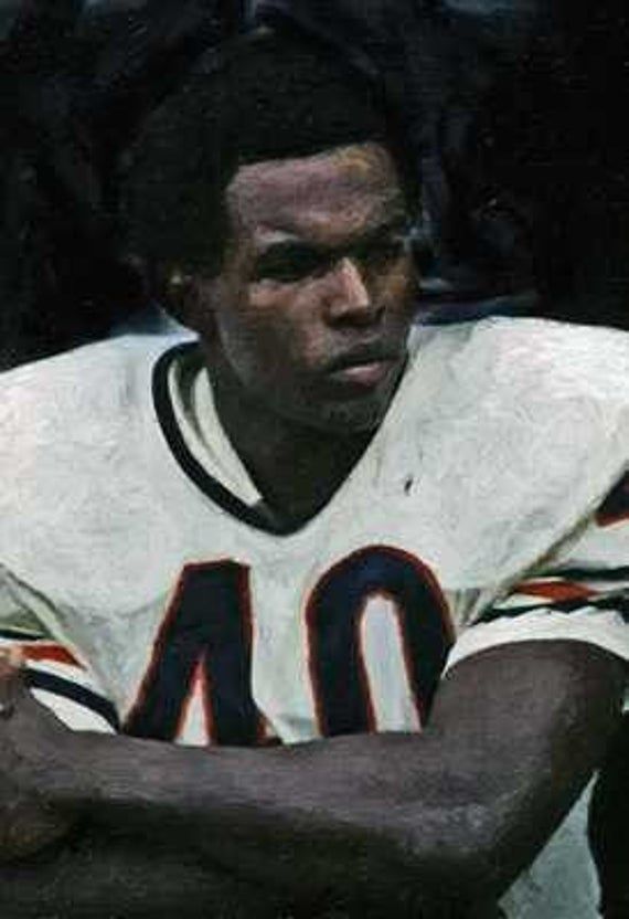 a football player sitting on the sidelines with his arms crossed in front of him