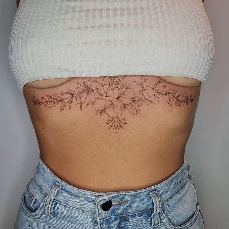 a woman with a flower tattoo on her stomach