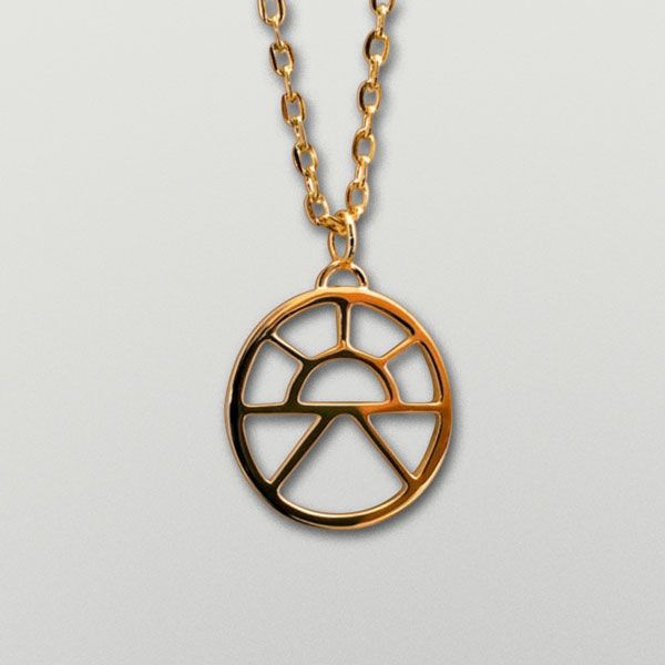 a gold necklace with an image of a wheel on the front, and a chain attached to it