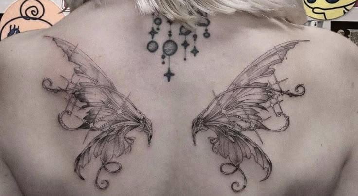 the back of a woman's chest with two wings on it and beads hanging from her hair