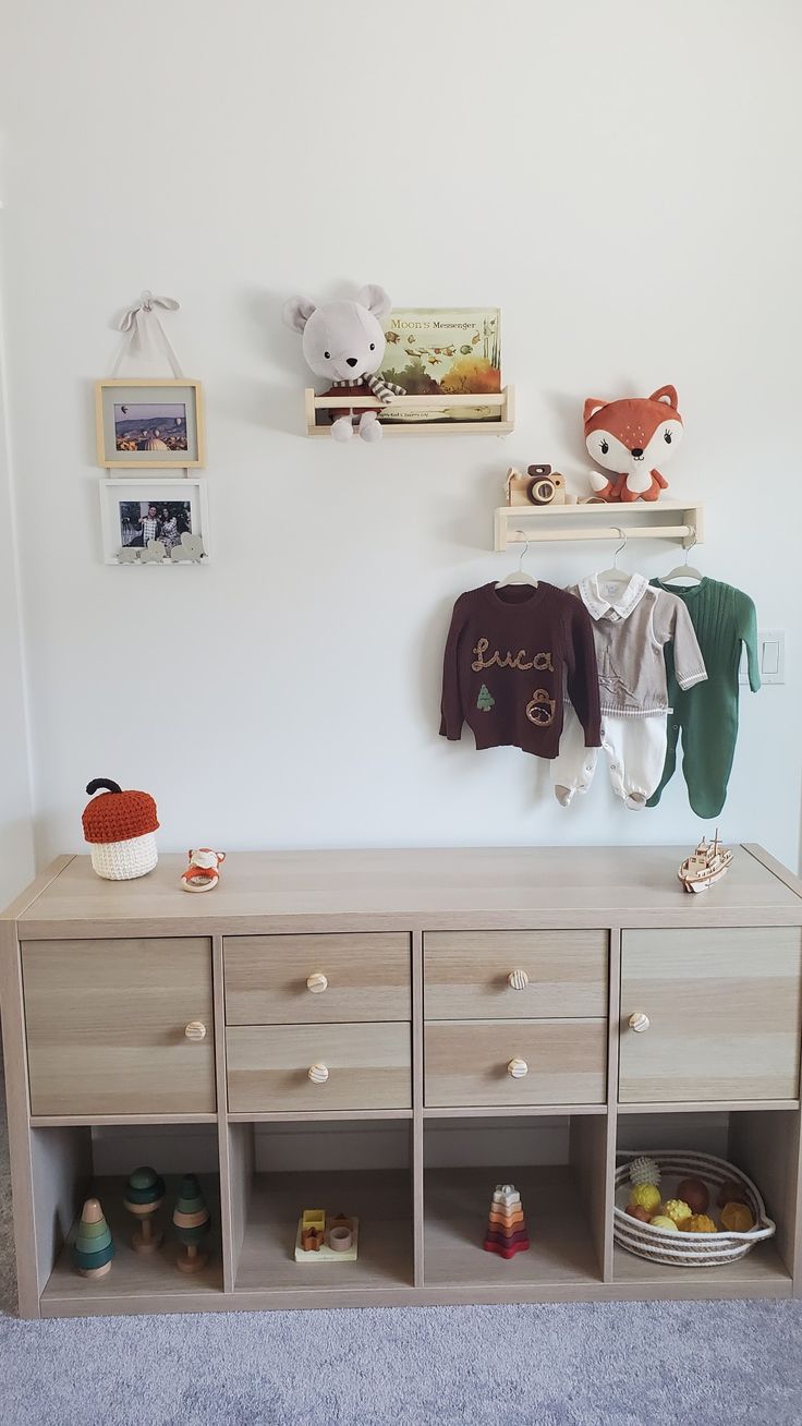 a baby's room with toys and stuffed animals on the wall, including a dresser