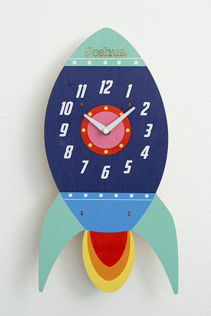 a wooden clock with a rocket ship design on the front and sides, painted in bright colors