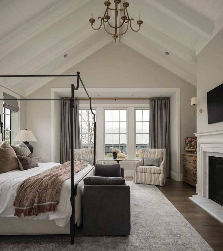 a bedroom with a large bed and a fireplace in the corner next to two couches