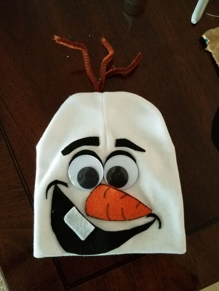 a close up of a hat on a table with an orange nose and black eyes