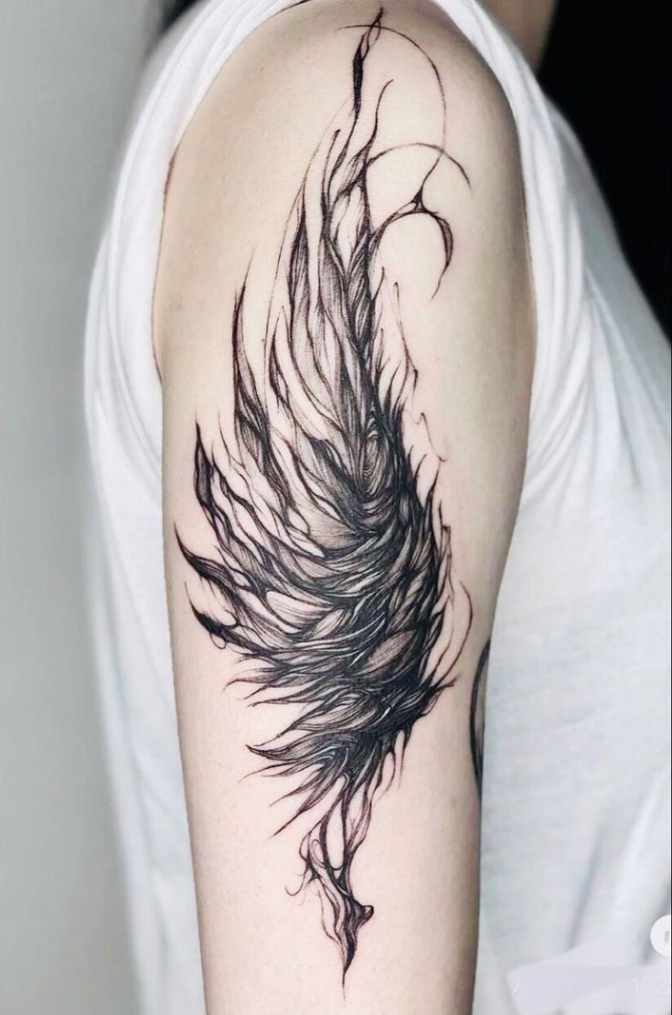 a woman's arm with a black feather tattoo on it