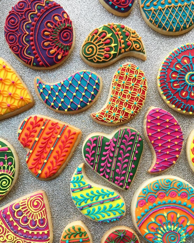 colorful decorated cookies are displayed on a counter top, including one with an intricate design