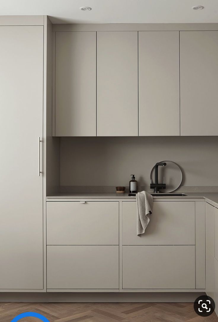 a kitchen with white cabinets and wood floors