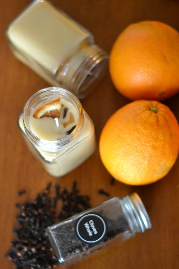 two oranges, an empty jar and some black tea on a table with other things