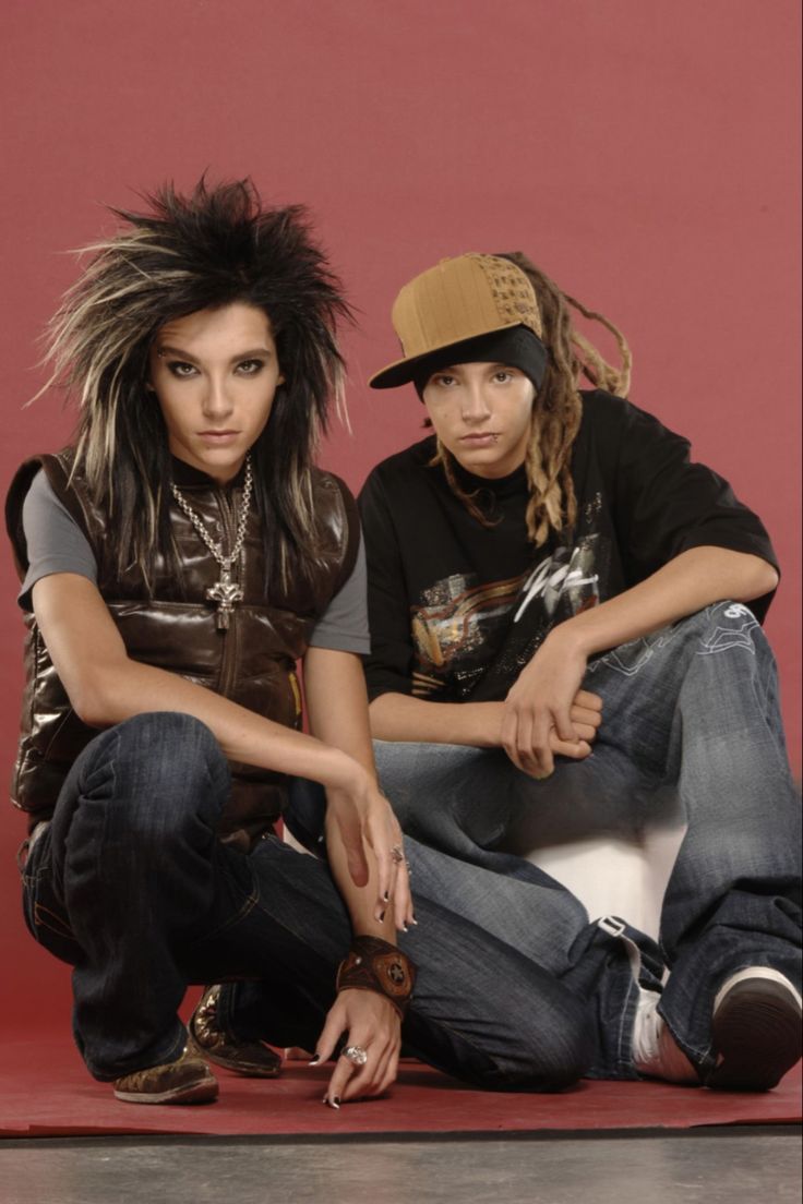 two young people sitting on the ground with their arms around each other