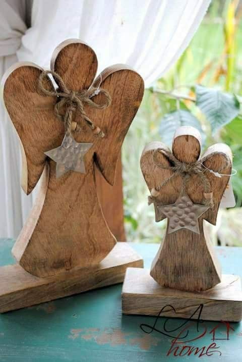 two wooden angel figurines sitting on top of a table