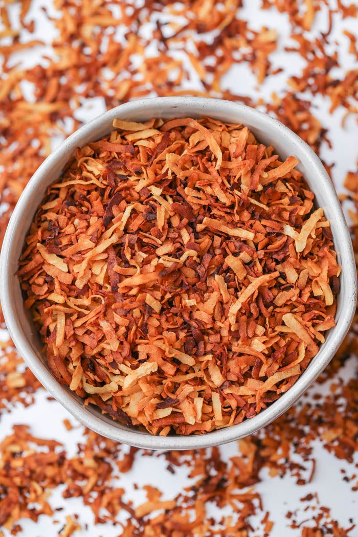 coconut bacon in a bowl on a white surface with the words coconut bacon written above it