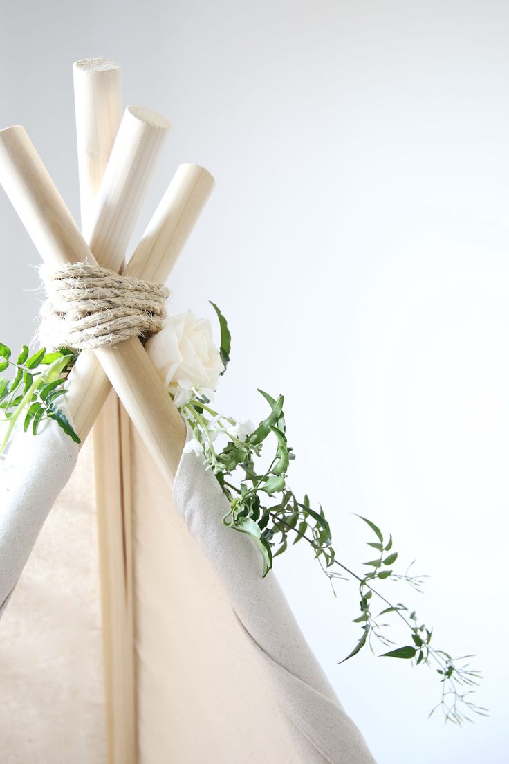 a teepee with white flowers tied to it