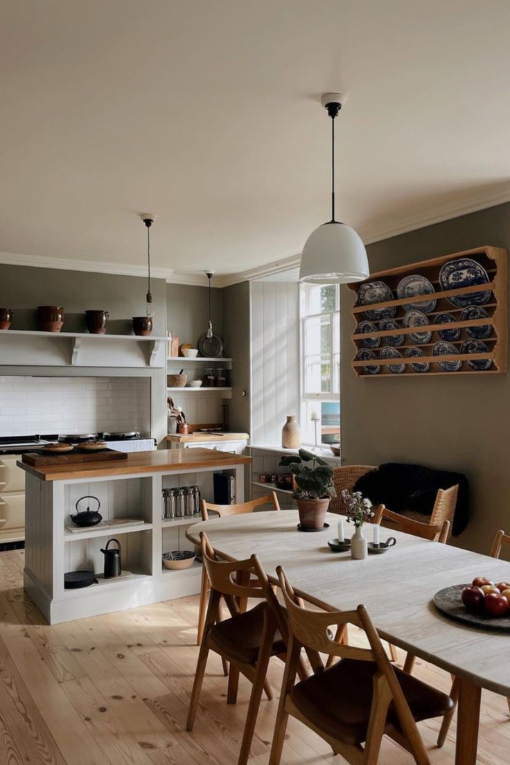 a dining room table with chairs around it in front of an open kitchen and breakfast nook