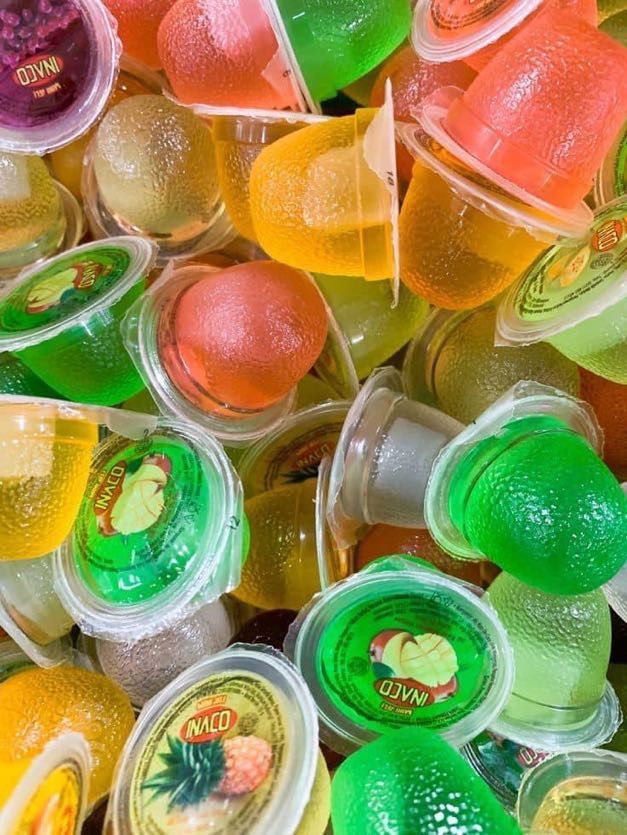 there are many different types of gummy bears in plastic cups on the table together