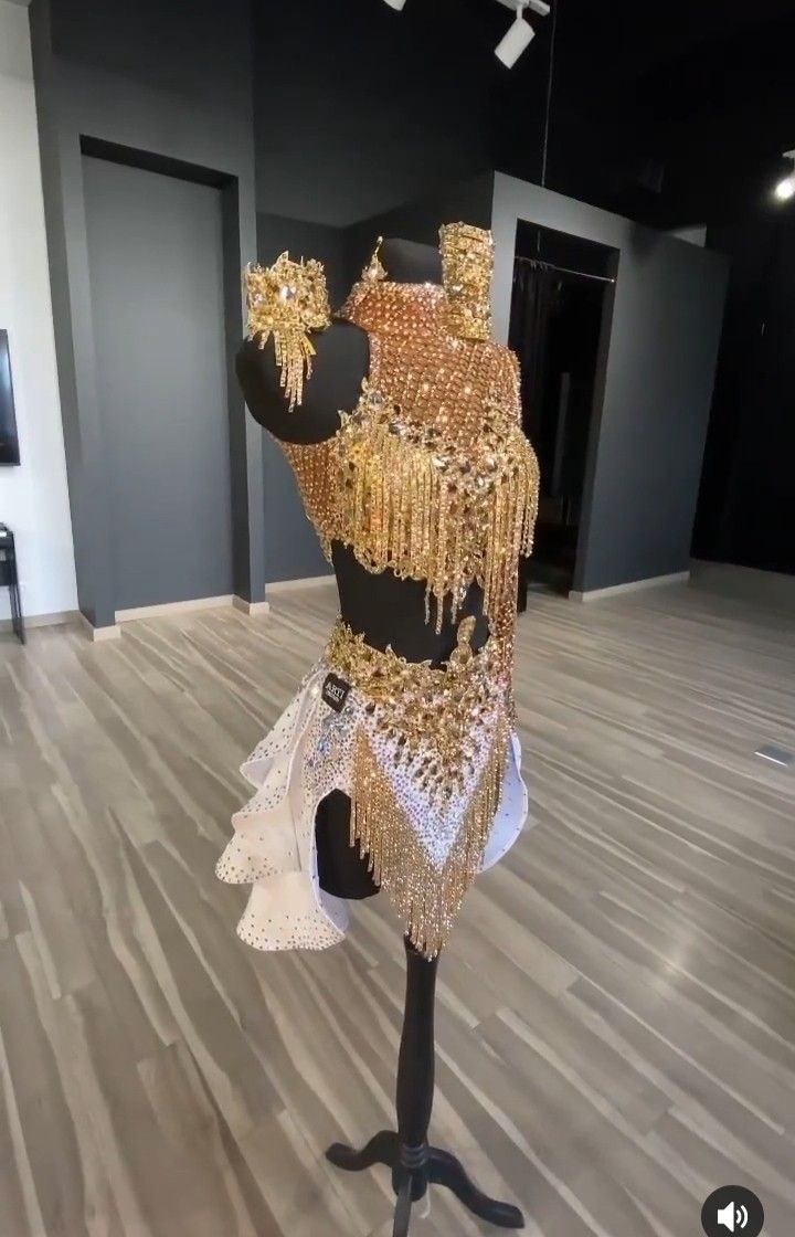 a mannequin dressed in gold and white with chains hanging from it's back