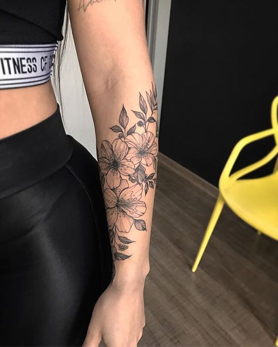 a woman with a flower tattoo on her arm