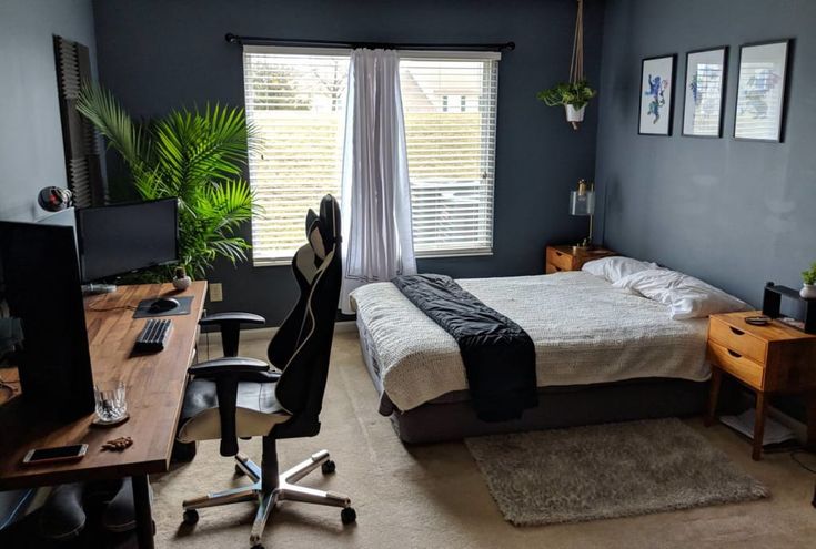 a bed room with a neatly made bed and a desk in front of a window