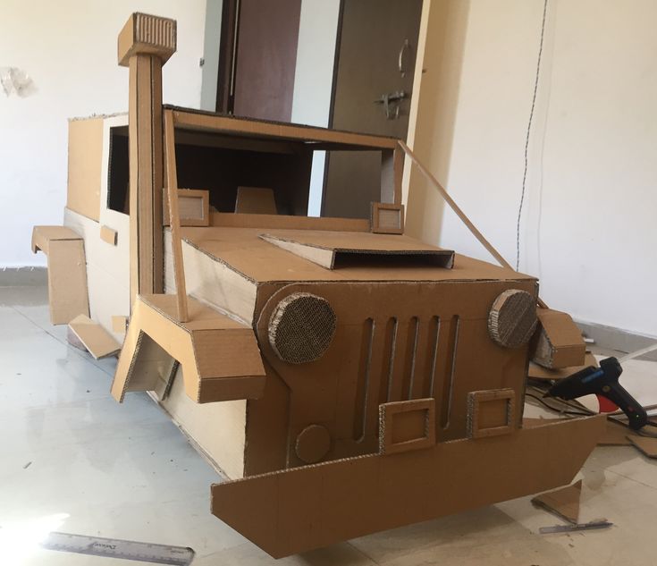 the cardboard jeep is made to look like it's being built into a house