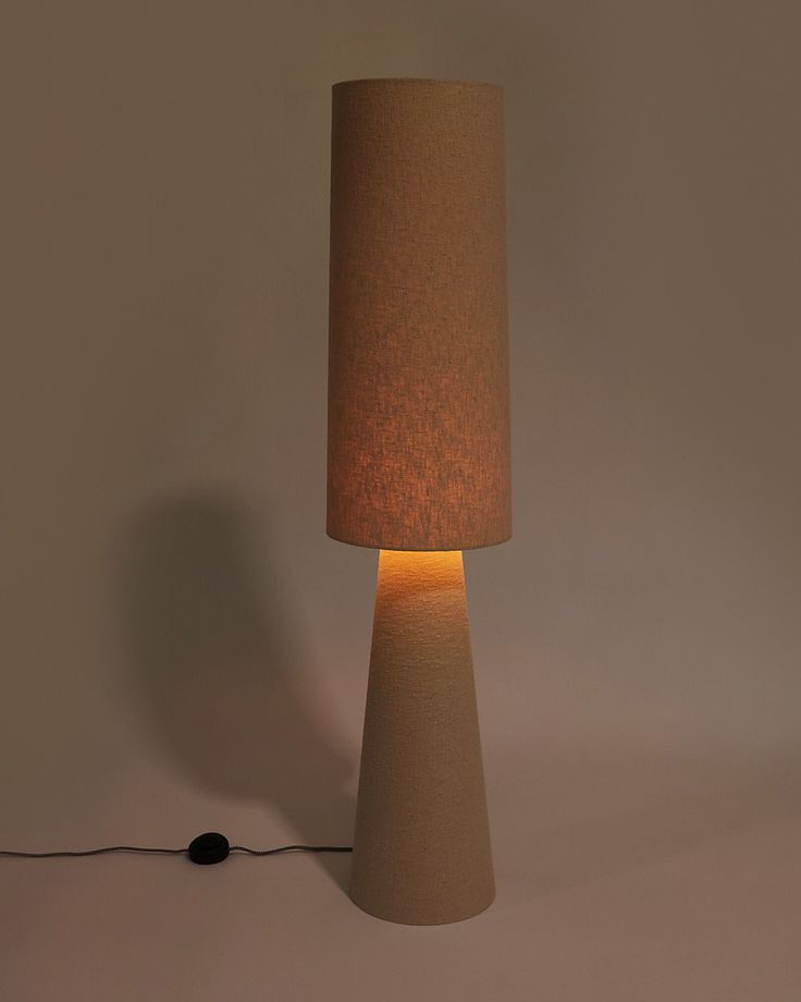 a lamp that is on top of a white surface with a cord attached to it