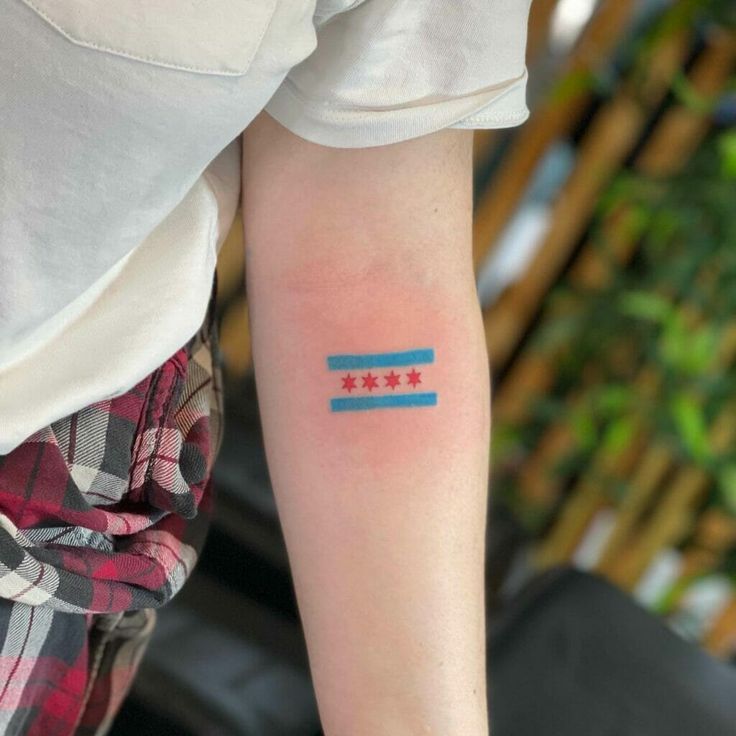 a person with a small tattoo on their arm that has two stars in the middle