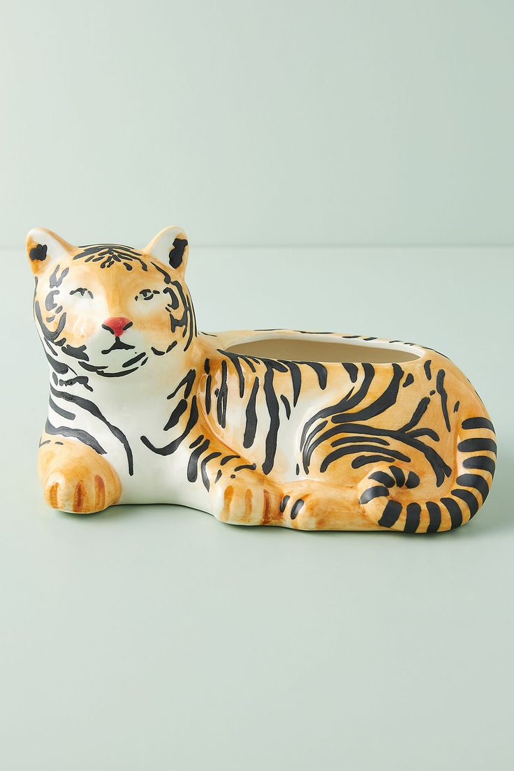 a ceramic figurine of a tiger laying down