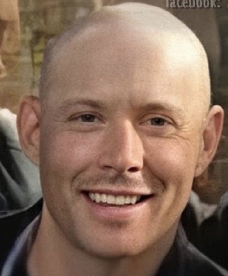 a man with a bald head smiling at the camera