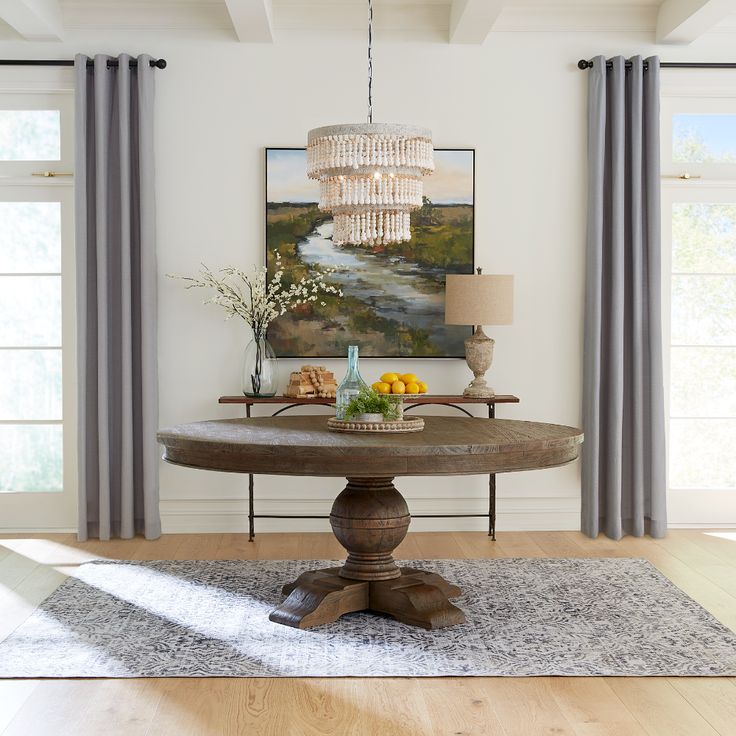 a dining room with a chandelier hanging from the ceiling and a painting on the wall