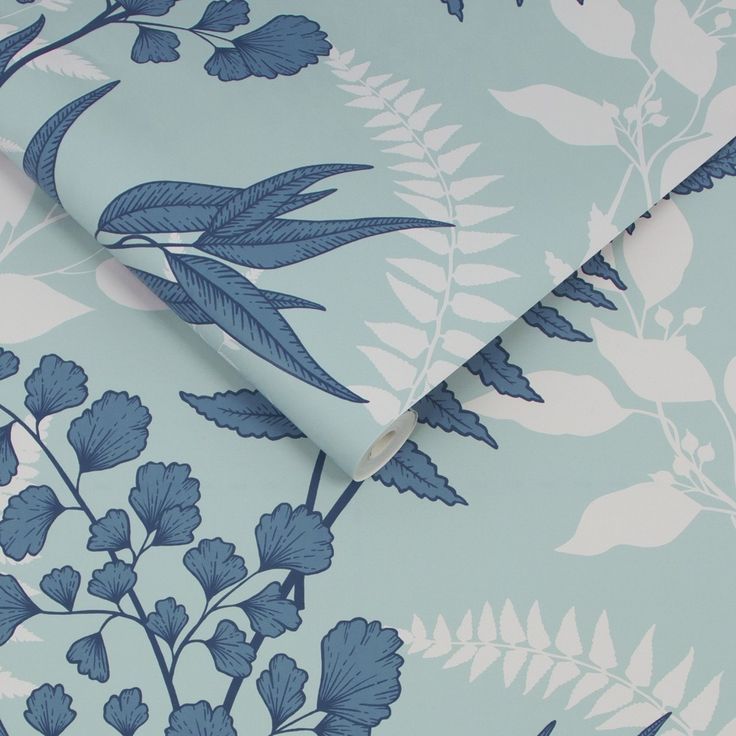 a blue and white wallpaper with leaves on it's side, in the background is a plant pattern