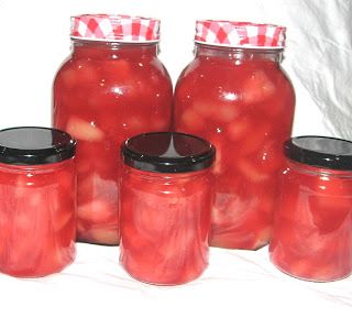 several jars filled with red liquid sitting on top of a table