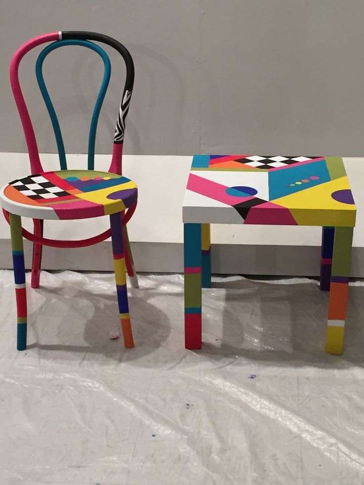 two colorful chairs sitting next to each other on top of a white sheeted floor